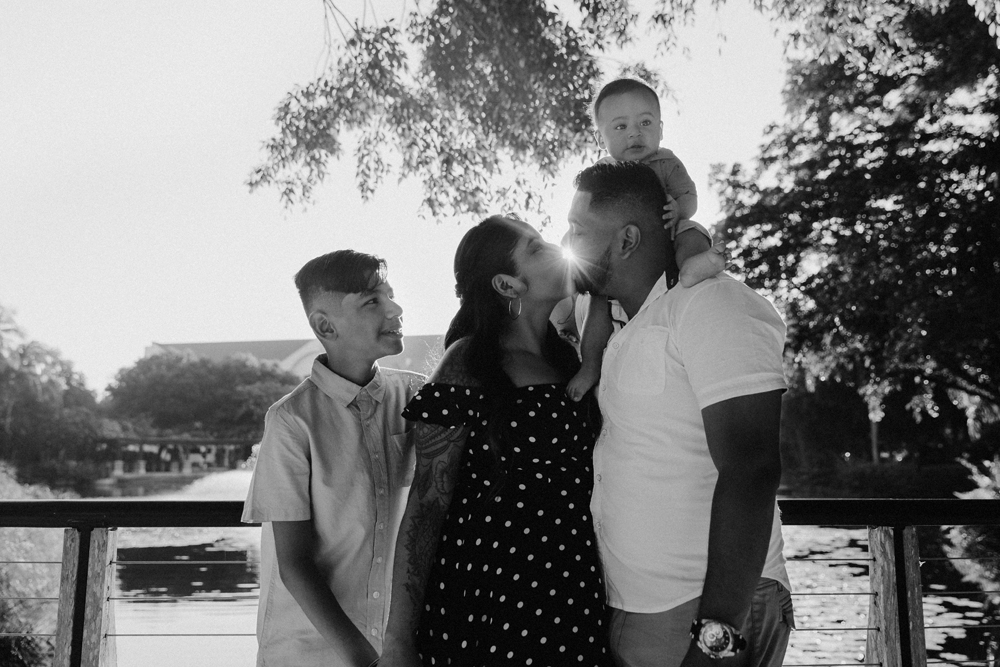 Naples Family Photographer, black and white image of family with mother and father kissing