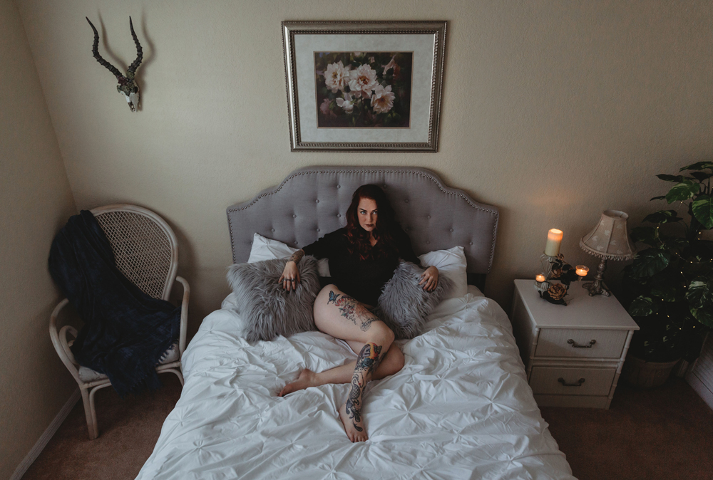 Naples Boudoir Photographer, woman sitting on a bed surrounded by pillows