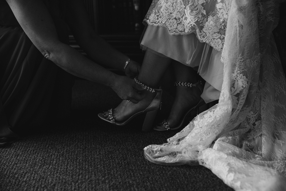 Naples Wedding Photographer, close up of someone clasping the brides shoes